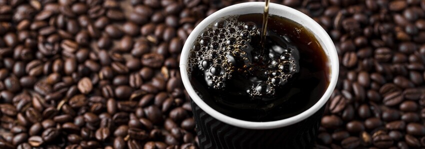Americano con granos de café al fondo